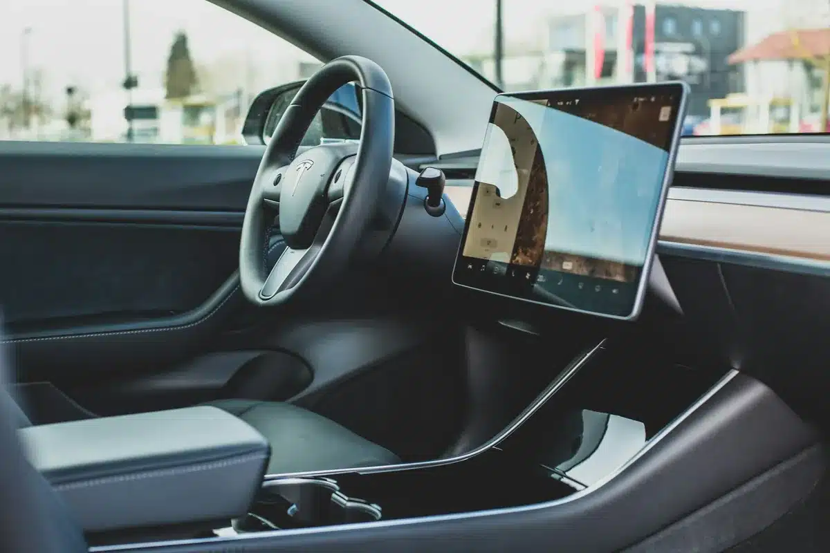 The interior of a Tesla showing the tablet interface and steering wheel