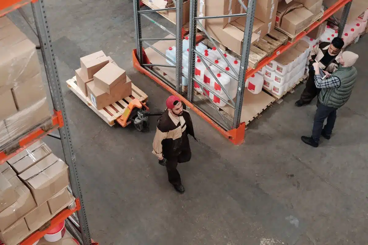 manufacturing employee walking in the warehouse with an order of products