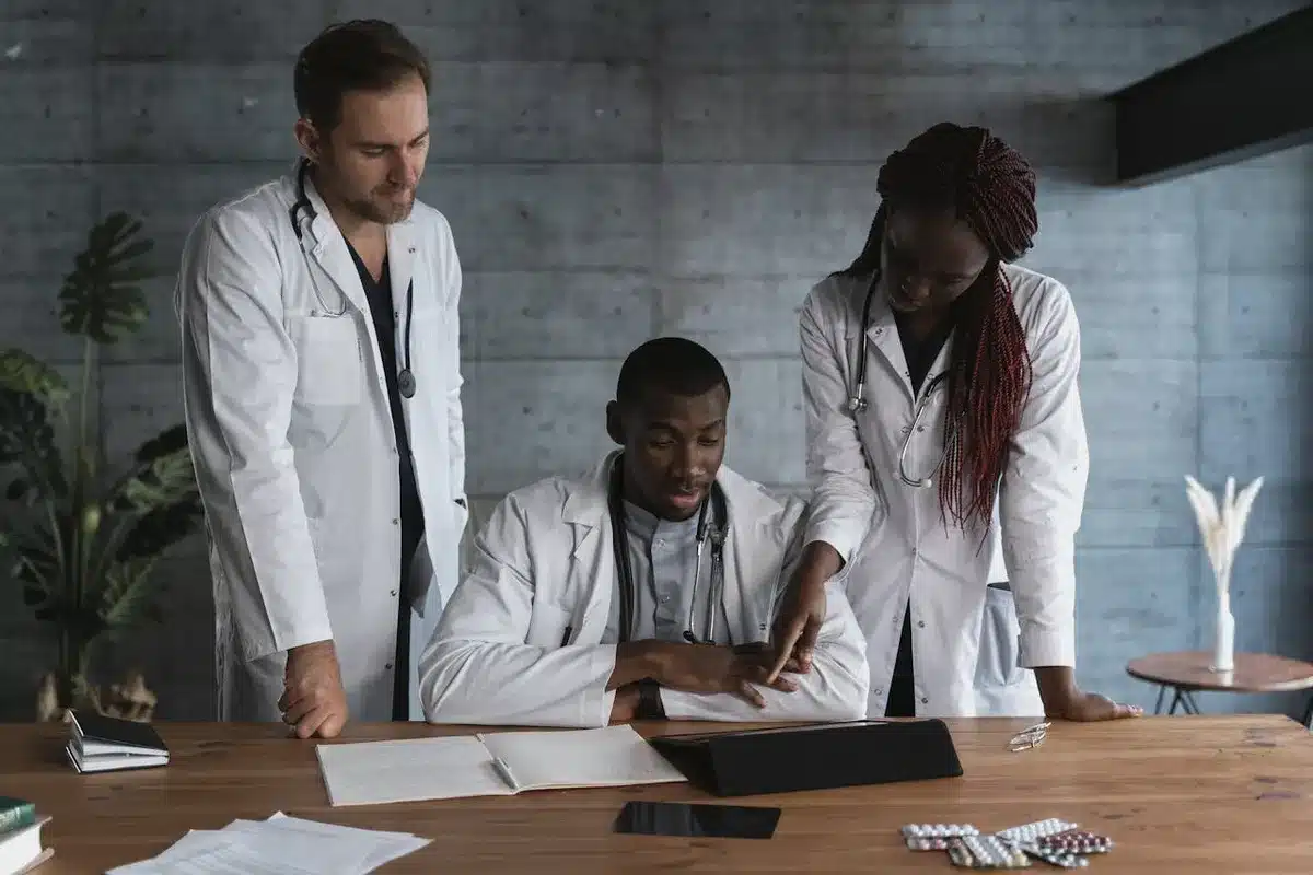 Three doctors checking notes of a patient